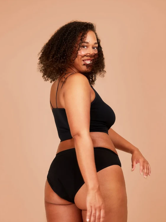 Czarne majtki menstruacyjne Fluxies Essential Hipster na kobiecej sylwetce, widok z tyłu