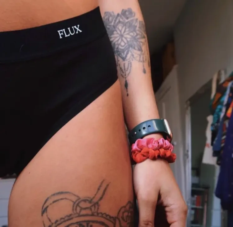 Zbliżenie na czarne majtki menstruacyjne Fluxies Hipster z widocznym tatuażem na biodrze