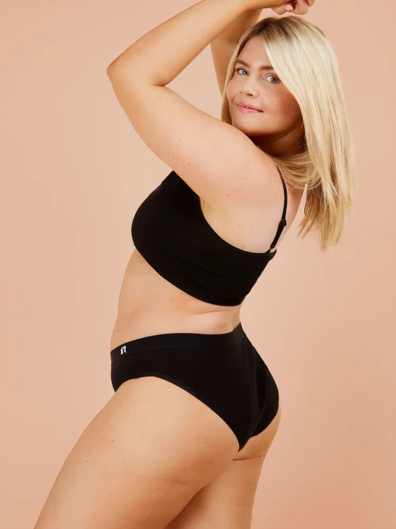 Czarne majtki menstruacyjne Fluxies Hipster na kobiecej sylwetce, widok z boku