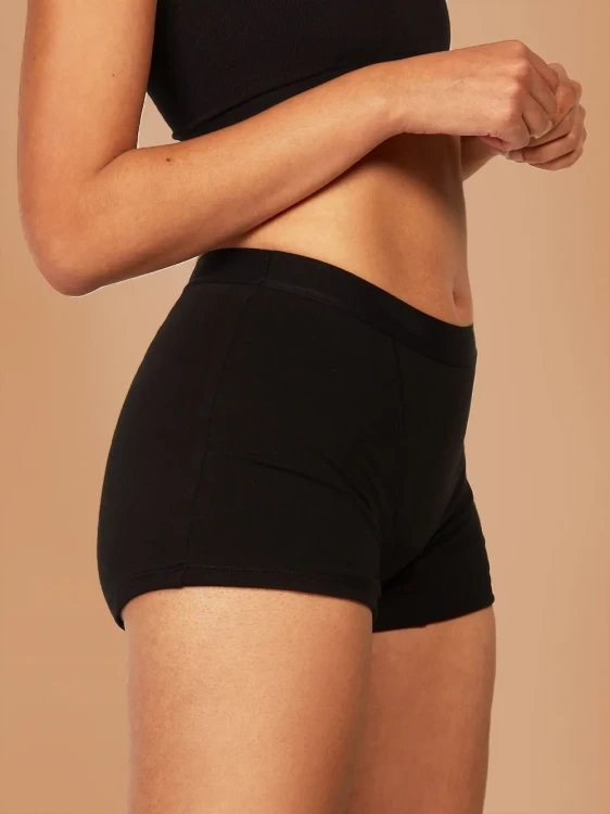 Czarne majtki menstruacyjne Fluxies Sleep Short o bardzo wysokiej chłonności na kobiecej sylwetce, widok z boku