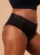 Czarne majtki menstruacyjne Fluxies Bikini z koronką w pasie na kobiecej sylwetce, widok z boku